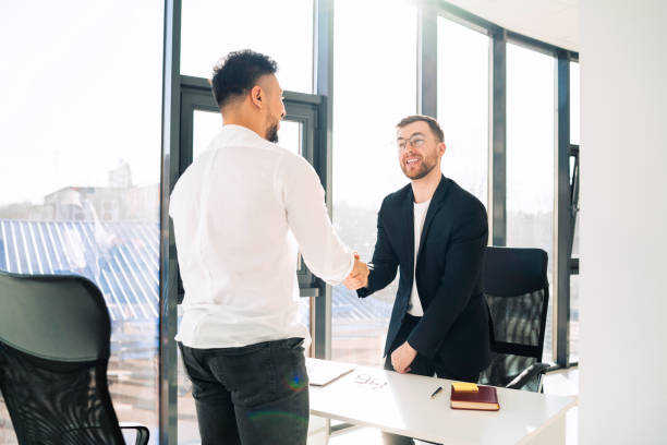 istock Two businessmen shake hands welcoming each other 1322672254