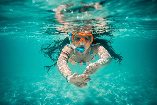 unterwasseransicht der schönen frau schwimmen in blauem meerwasser - schnorchel stock-fotos und bilder