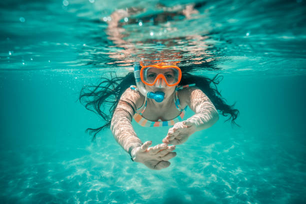 vista submarina de la hermosa mujer nadando en el agua azul del océano - snorkel fotografías e imágenes de stock
