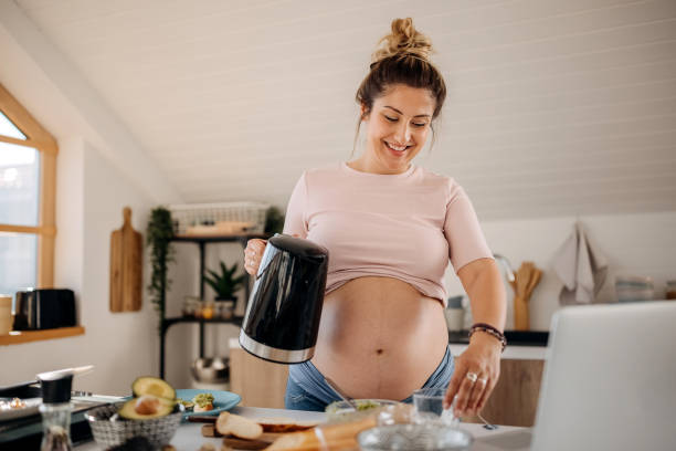 istock Young pregnant woman making a tea in kitchen 1322676154