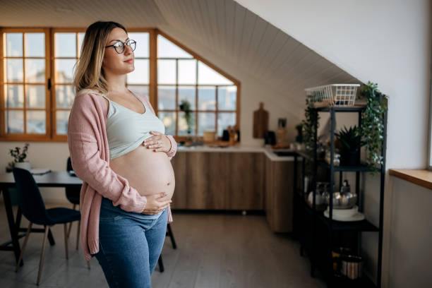 istock Young pregnant mother posing at her home touching her belly 1322676230