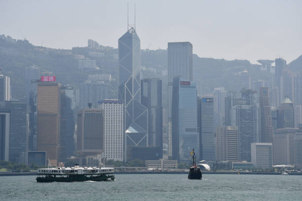 Star Ferry in Victoria Harbour and Central Skyline in Hong Kong Hong Kong, China - August 9, 2019: A Star Ferry vessel in Victoria Harbour against the backdrop of skyscrapers in Central. the bank of china tower stock pictures, royalty-free photos & images