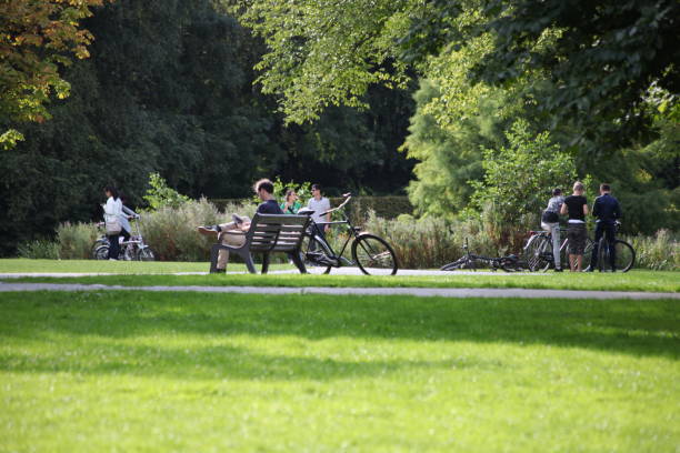 Young hipster businessman taking a break, resting on bench in the park, by his bike
