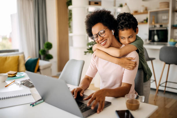 istock Happy mother working from home hugging with her son 1322676630