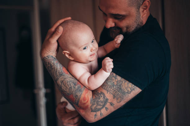 padre barbuto tatuato che gioca con suo figlio - tattoo father family son foto e immagini stock