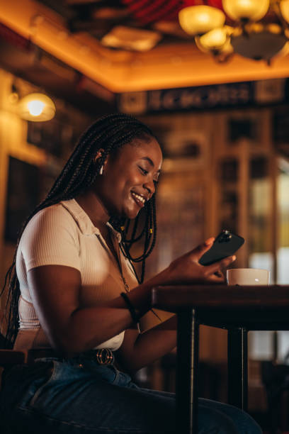 istock frican american woman using smartphone while drinking coffee in a cafe 1322677824