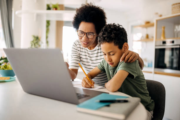 istock Mother helping son studying with laptop on a online class at home 1322678049