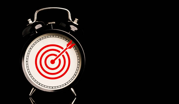 istock Red target board with arrow inside of alarm clock on black background and copy space , time and business target concept. 1322679976