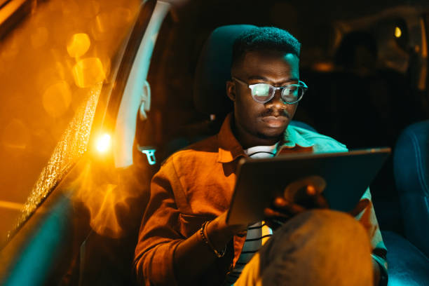 istock Handsome young businessman using digital tablet in car 1322680102