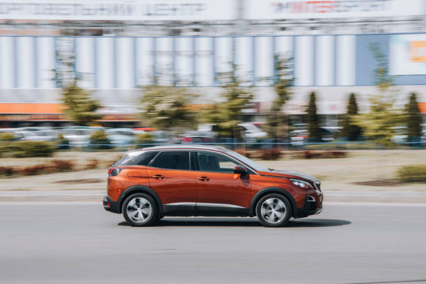 brauner bmw x1 auto bewegt sich auf der straße. - bell stock-fotos und bilder