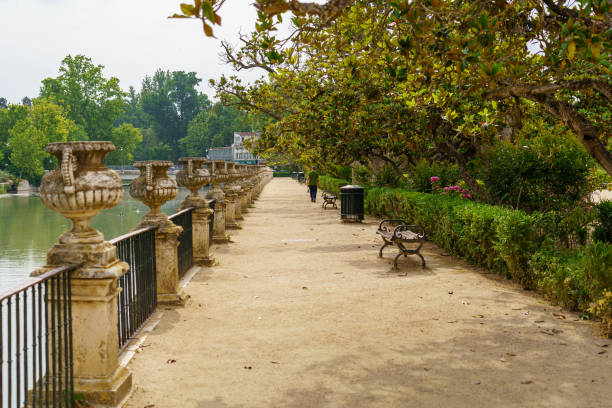 Dirt road in the park next to the Tagus river and people walking and resting. Aranjuez. Dirt road in the park next to the Tagus river and people walking and resting. Aranjuez. aranjuez stock pictures, royalty-free photos & images