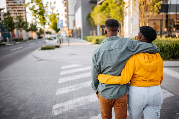 istock Young couple walking on the street hugging 1322686916