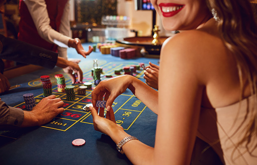 Chips in the hands of a female roulette player in casino background. Casino betting gambling game poker roulette concept.