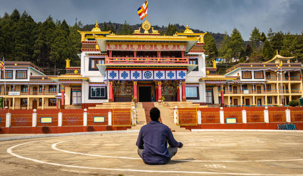 istock young man meditating in lotus position in front of ancient monastery at day 1322687682