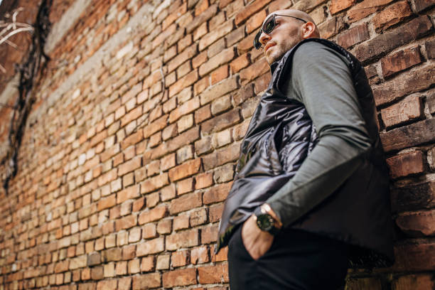 istock Fashionable man by a brick wall 1322689183