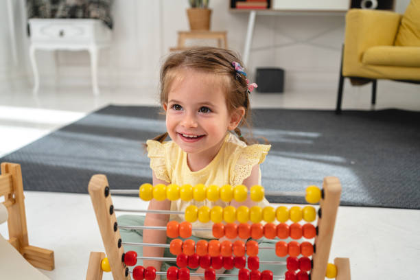 istock Curious toddler girl playing with abacus developing her sensory perception 1322689806