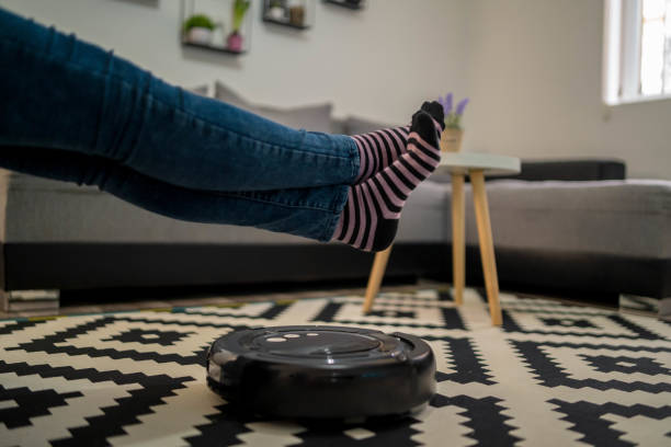 istock One woman, at home relaxing, while robot vacuum cleaner is working. 1322690446
