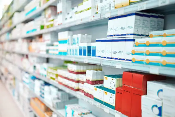 Photo of Cropped shot of shelves stocked with various medicinal products in a pharmacy