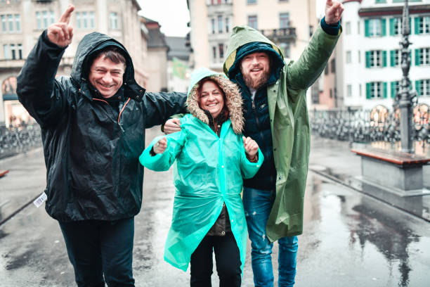 glückliche familie genießt regentag im urlaub in luzern, schweiz - happy men rain water dance stock-fotos und bilder