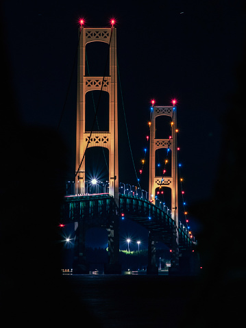 The Mackinac Bridge lights at night connecting the peninsulas of Michigan