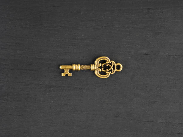 istock Bronze antique small key on black wooden background 1322696591