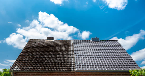半分きれいな家の屋根は屋根のクリーニングの前後の効果を示す。 - roof tile ストックフォトと画像