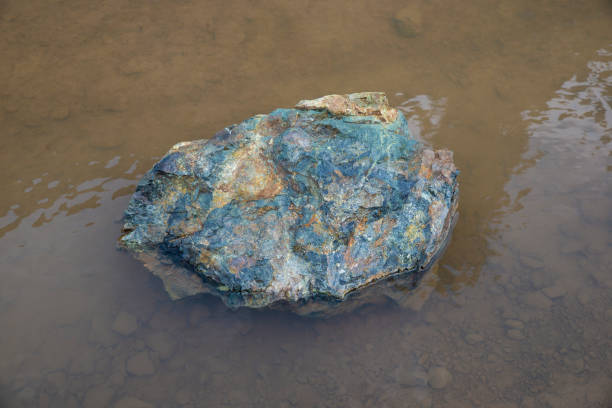 istock Natural stone with multple colors inside water pond 1322699561