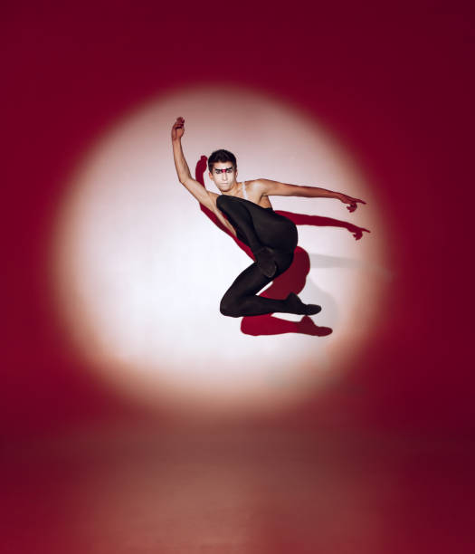 istock Ballet dancer dancing over red studio background. Modern design. Contemporary colorful conceptual light as rising sun at Japan. 1322700181