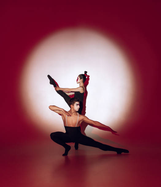 istock Ballet dancers dancing over red studio background. Modern design. Contemporary colorful conceptual light as rising sun at Japan. 1322700246