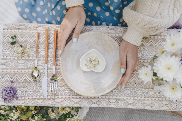 donna che decora il tavolo per un picnic - plate dinning table blue foto e immagini stock