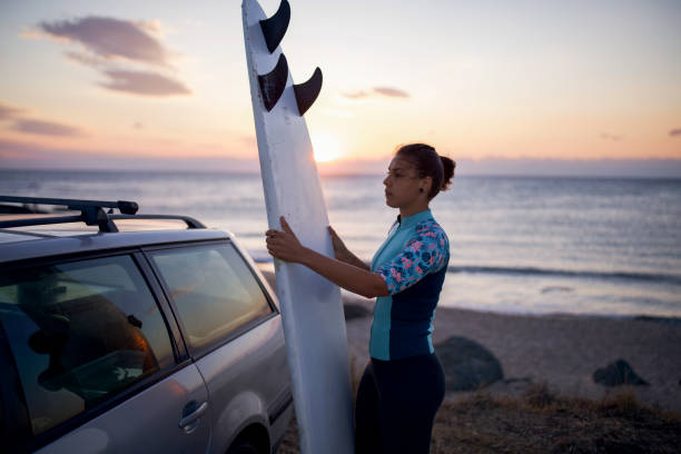 istock Woman preparing for surfing at sunrise. 1322705775