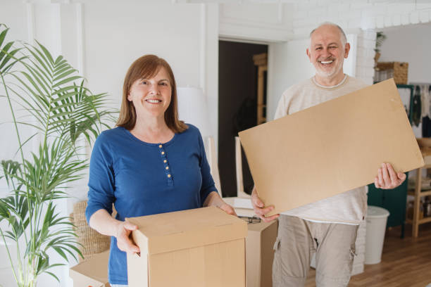 istock Senior couple carrying boxes into new home on a moving day. 1322709197
