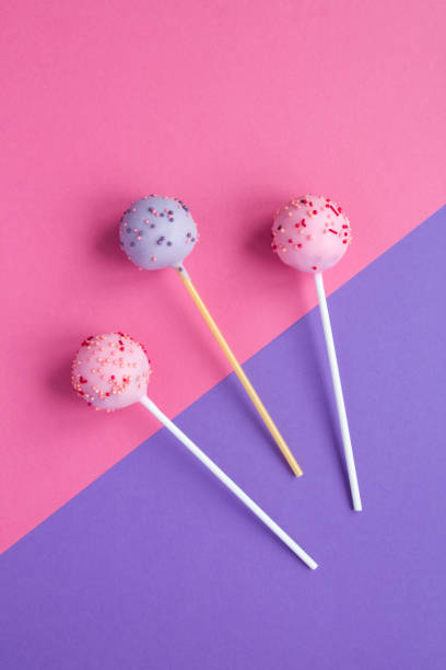 istock Cake pop with pink and purple glaze on the colored background 1322710597