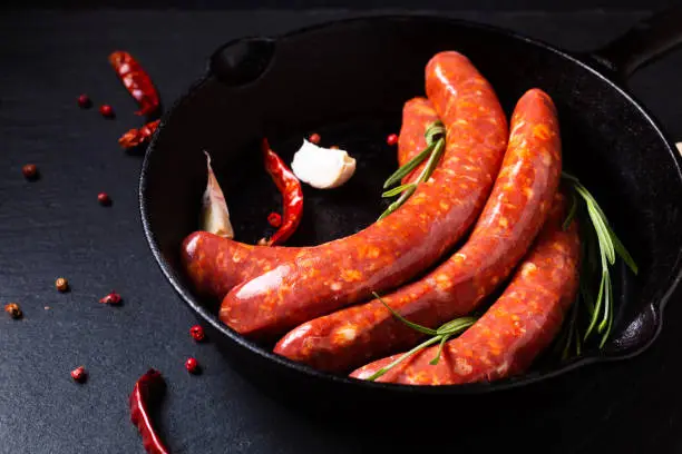 Photo of Food concept Merguez French spicy sausages in skillet iron pan with copy space