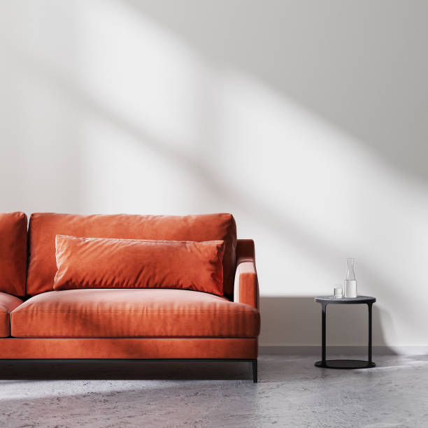 istock red sofa with black coffee table in empty room with white empty wall with sun rays, raw concrete floor, scandinavian minimalistic style, 3d rendering 1322713298