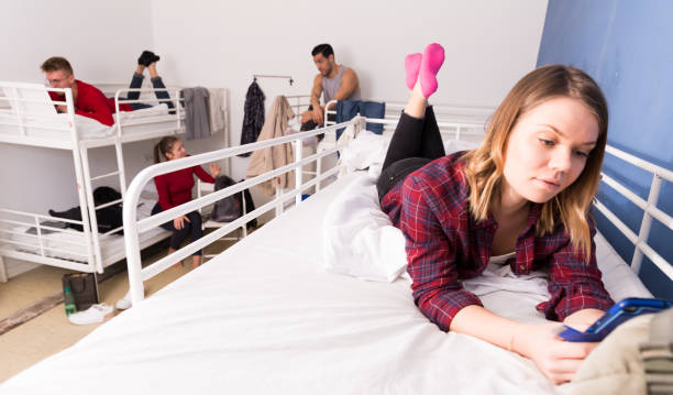 istock Girl with phone lying on bed in hostel 1322713841