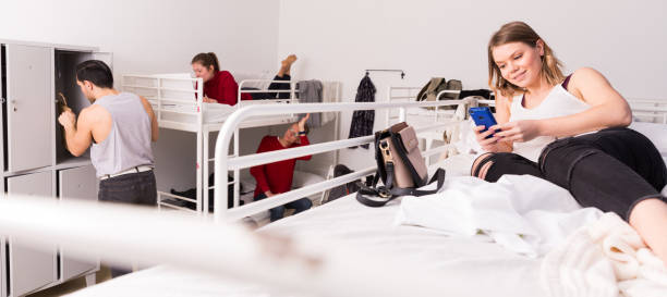 istock Woman lying on bed in hostel with smartphone 1322713843