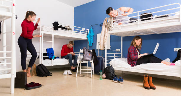 istock Young men and women friendly interacting while staying in modern comfy hostel 1322713846