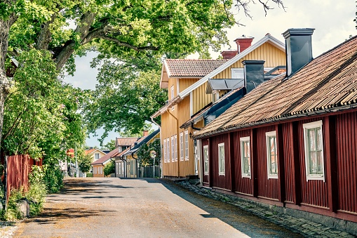Old houses in the city of Västervik in Sweden. In the background is the church tower of Saint Gertrude's church.