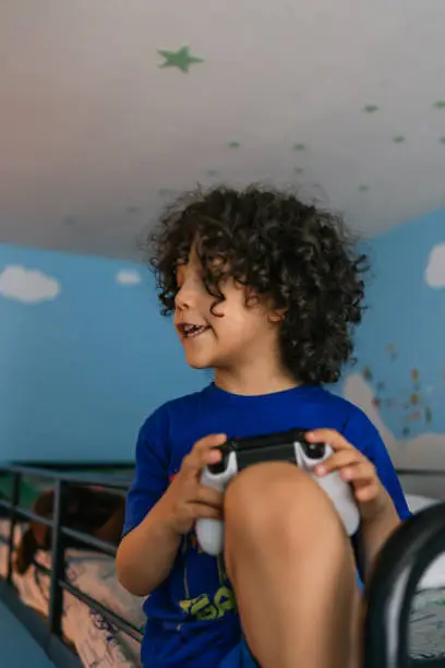 Little boy sitting in the top of the stateroom playing video games