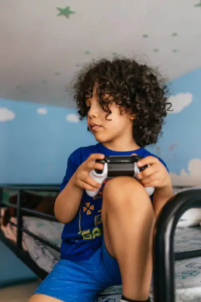 Little boy sitting in the top of the stateroom playing video games