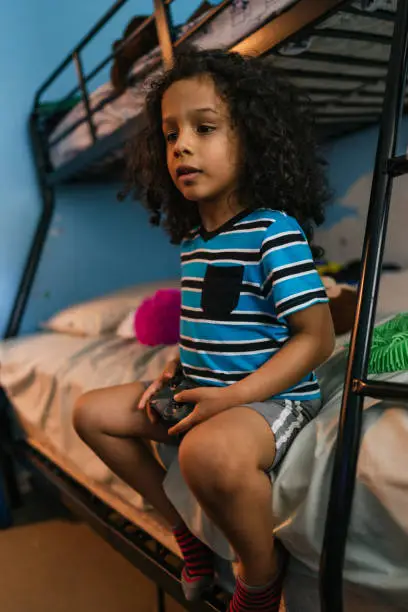 Little boy sitting in the stateroom playing video games