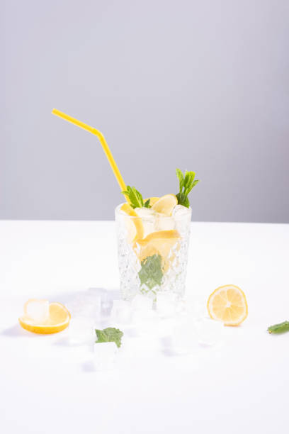 istock minimalistic refreshing summer drink cocktail with lemon, mint and ice cubes on white background 1322720225
