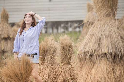 Asian Chinese woman enjoying short trip at rice paddy field in weekend.