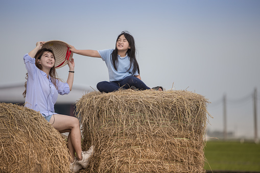 Asian Chinese mother daughter enjoying short trip at rice paddy field in weekend.