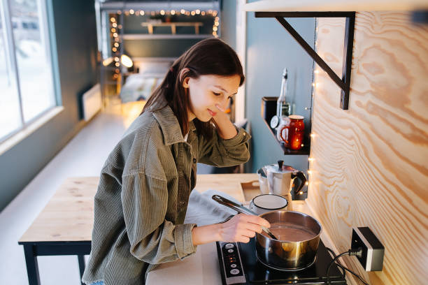istock Patient woman cooking on a high kitchen table, stirring soup on a stove 1322721804