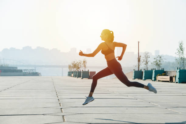 istock Athletic brunette running on the pavement outdoors. Low angle 1322722568