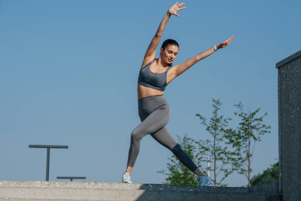 istock Relaxed brunette exercising outdoors, outstretching hands 1322722572