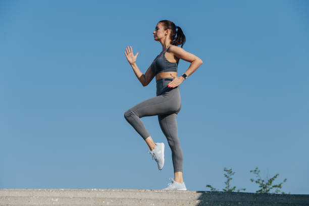 istock Side view on brunette exercising outdoors under a blue clear sky. 1322722590