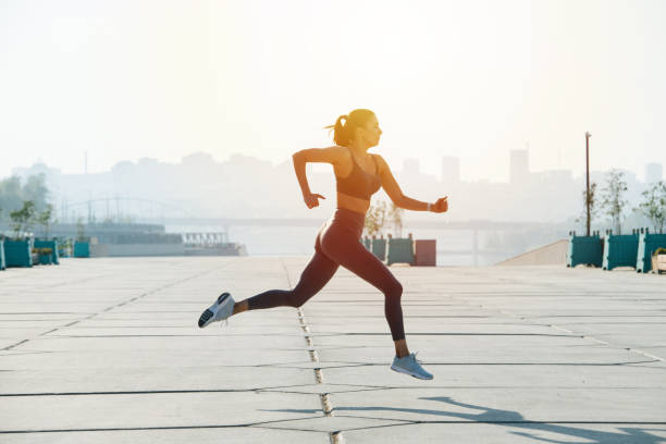 istock Trying hard brunette running on the pavement outdoors. Low angle 1322722641